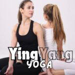 Ladies dressed in black and white doing yoga on a purple mat