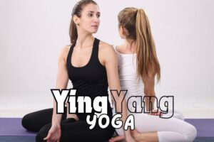 Ladies dressed in black and white doing yoga on a purple mat