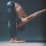 A guy performing a challenging yoga exercise, pushing himself to his limits